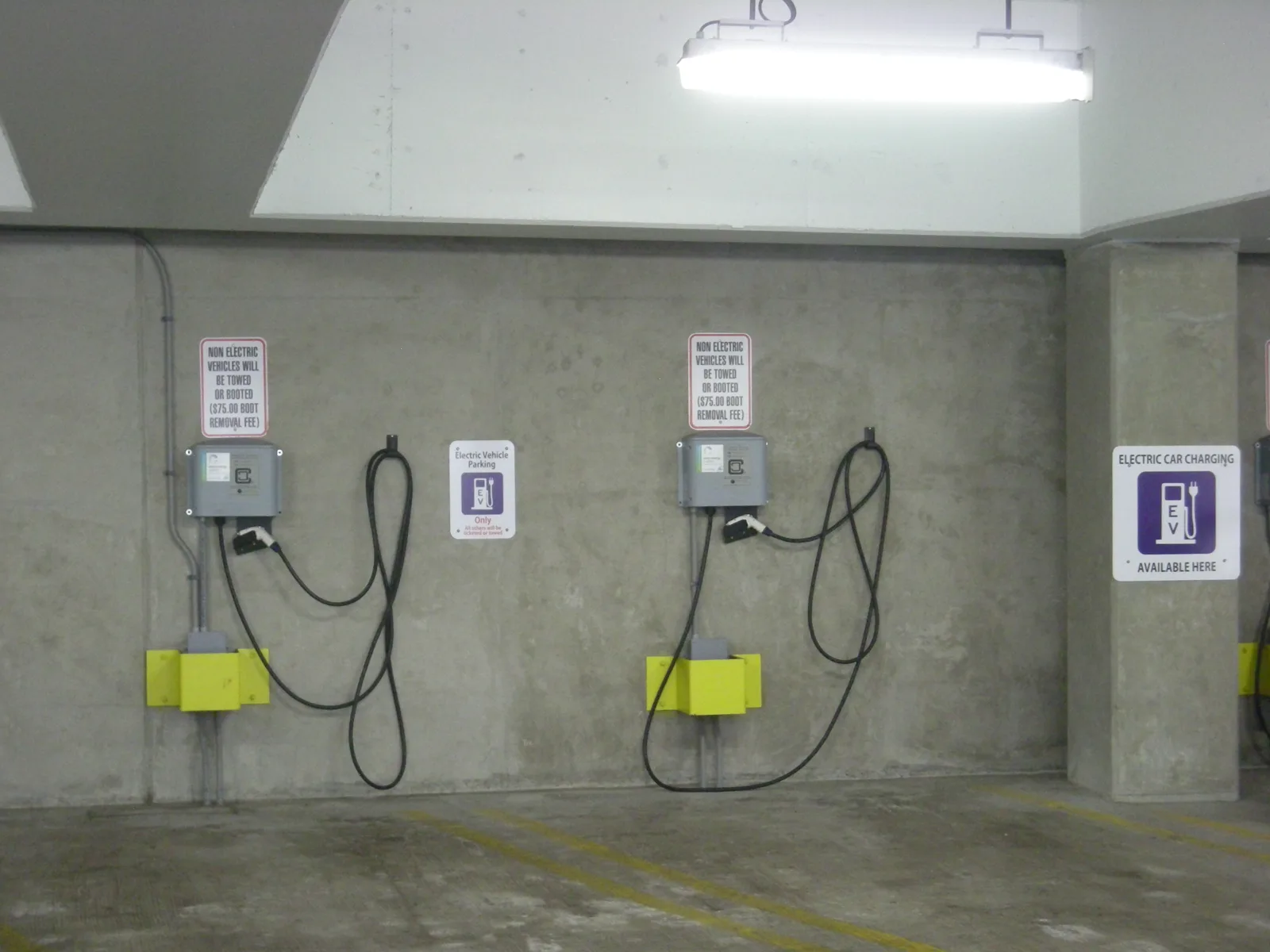 Wall-mounted electric vehicle chargers inside the Library Lane underground parking structure in Ann Arbor, Michigan. The picture does not show a Homewood deck.