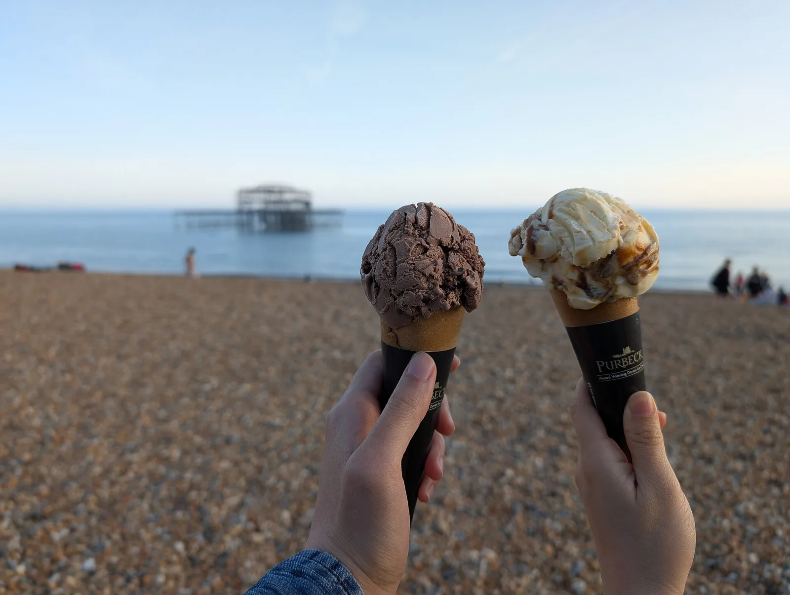 Two scoops of ice cream in waffle cones, one chocolate and one banoffee, bought at a beach hut in Brighton, England.