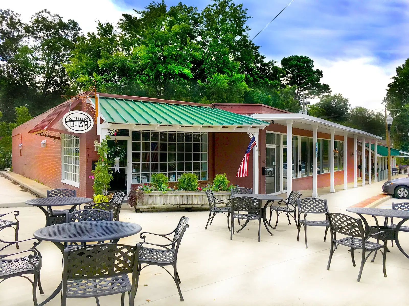 Shops with sidewalk tables in West Homewood, near Patriot Park