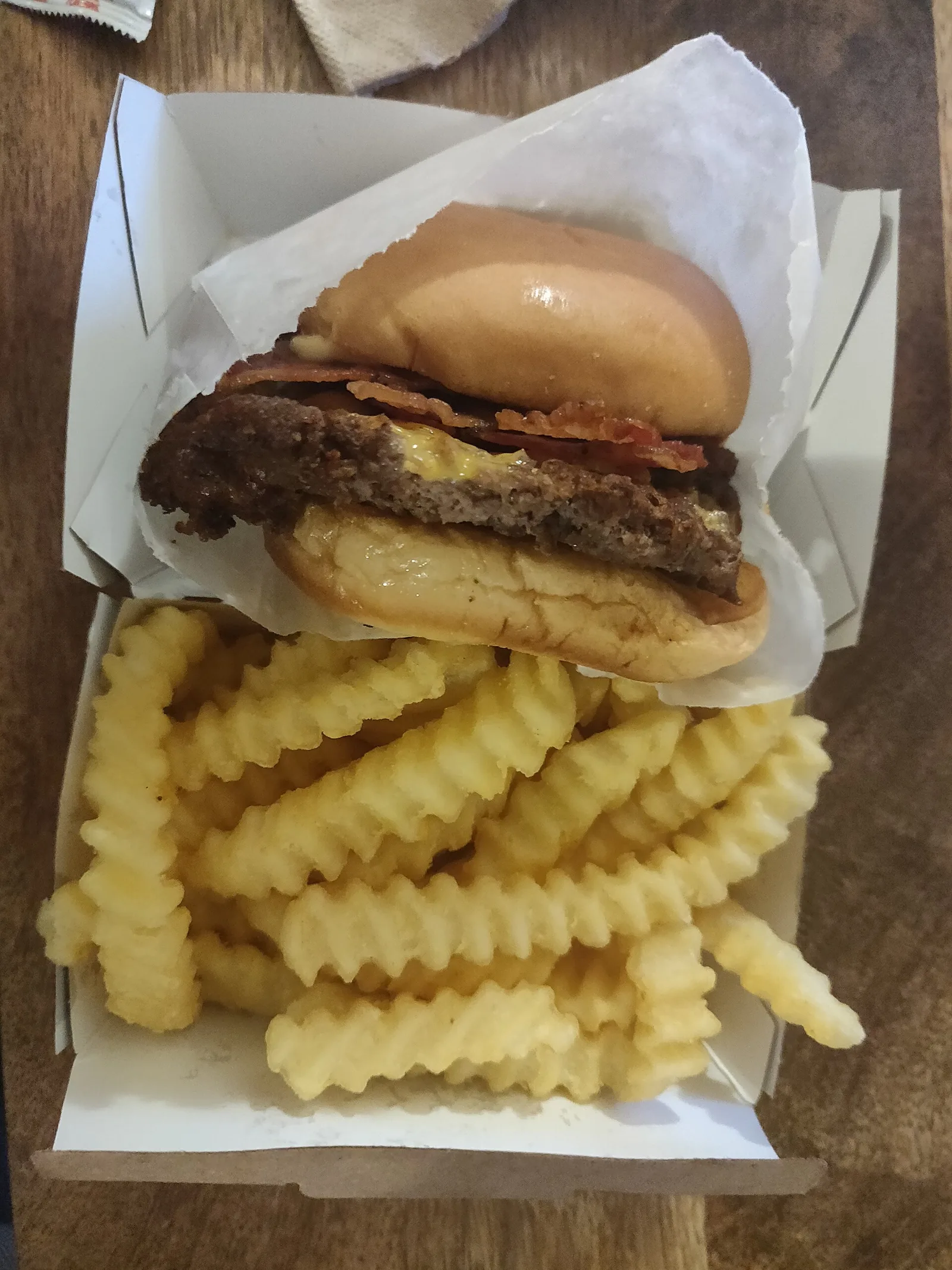 A cheeseburger with crinkle-cut fries.